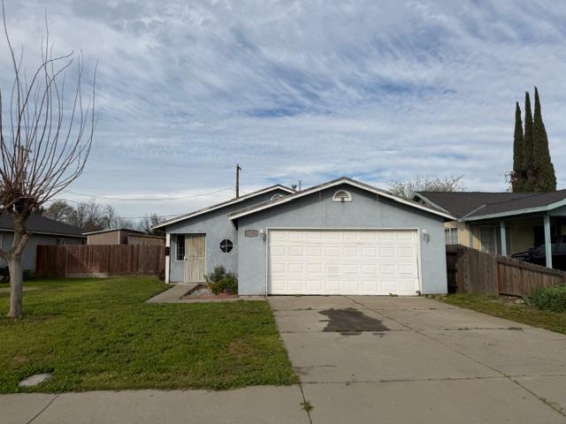 1340 Bennett Avenue Dos Palos, CA 93620 - Photo 2 of 16 a front view of a house with a yard and garage