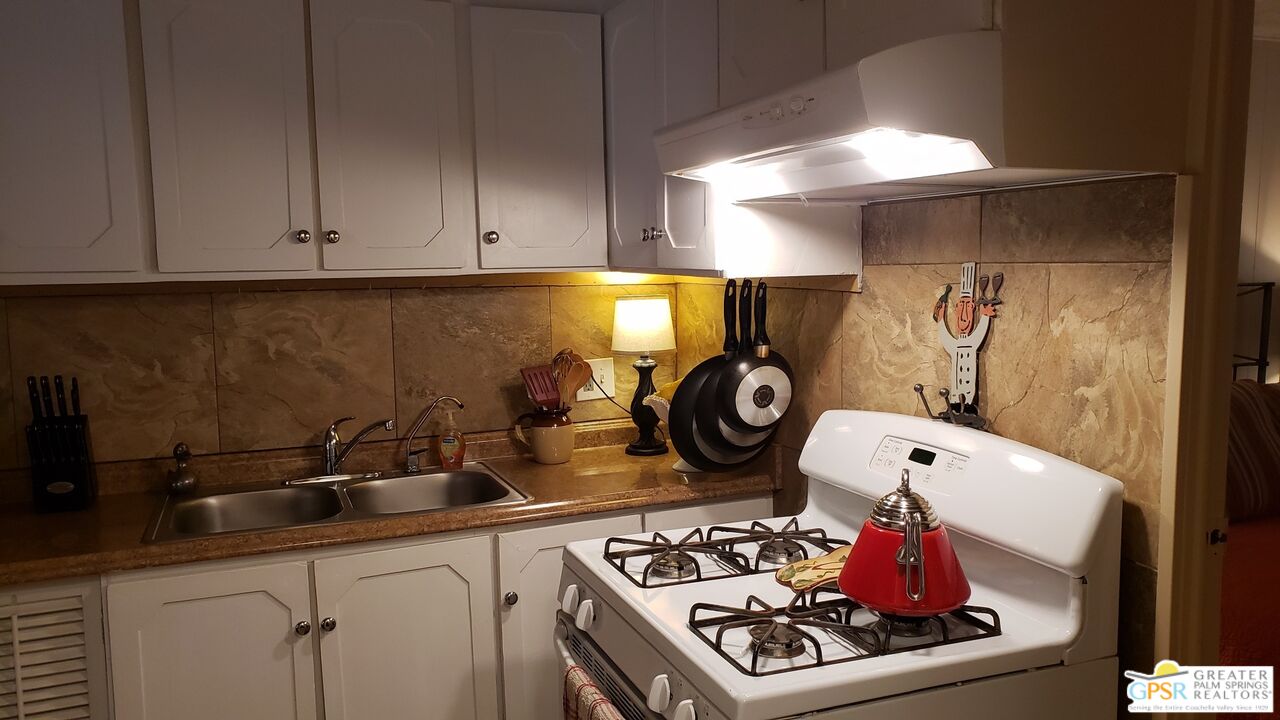 374 Buffalo Road Cathedral City, CA 92234 - Photo 9 of 33 a kitchen with a stove and cabinets