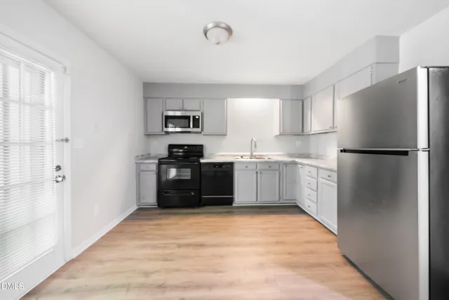 a kitchen with stainless steel appliances granite countertop a refrigerator and a stove top oven