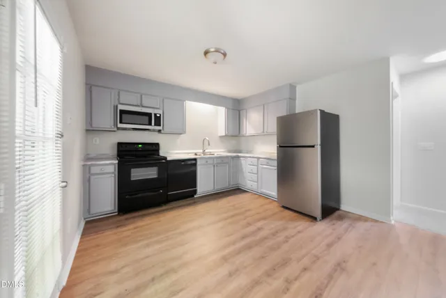 a kitchen with a refrigerator and a stove top oven