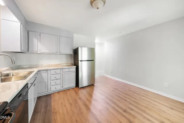 a kitchen with granite countertop a refrigerator and a sink