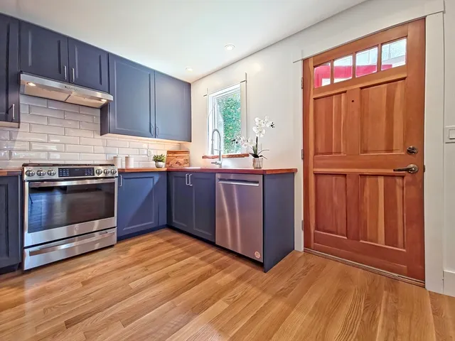 a kitchen with stainless steel appliances granite countertop wooden floors and sink