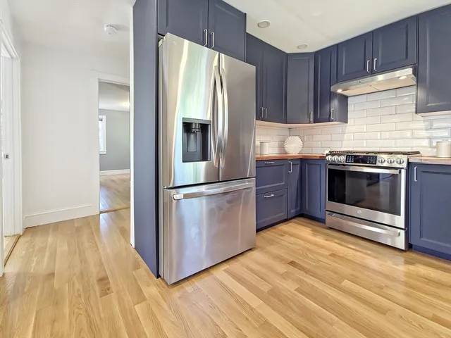 a kitchen with stainless steel appliances granite countertop a refrigerator and a stove