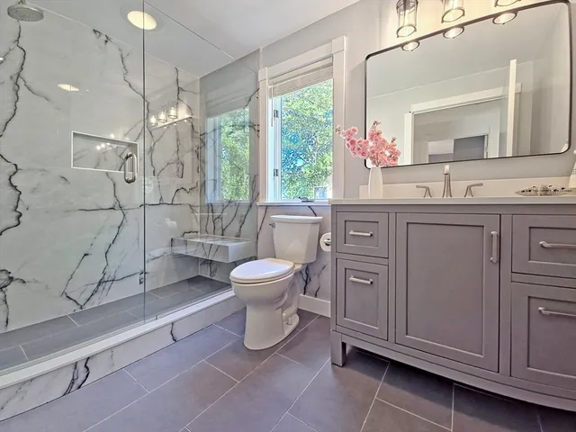 a spacious bathroom with a toilet sink and a mirror