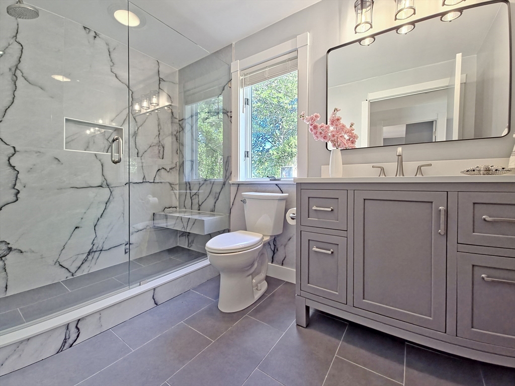 10 Squeteague Harbor Road Bourne, MA 02534 - Photo 15 of 41 a spacious bathroom with a toilet sink and a mirror