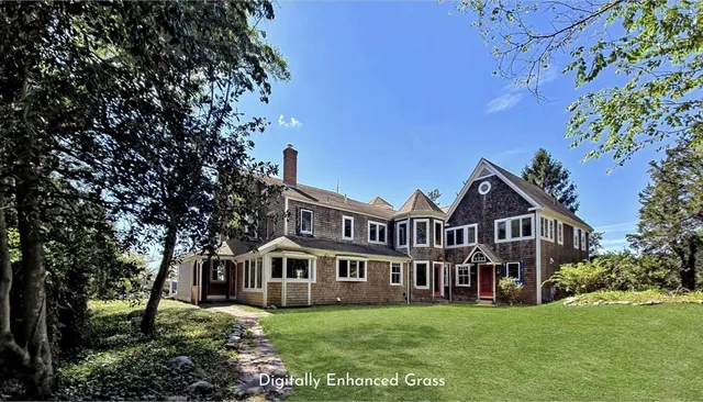 a view of a house with a big yard and large trees