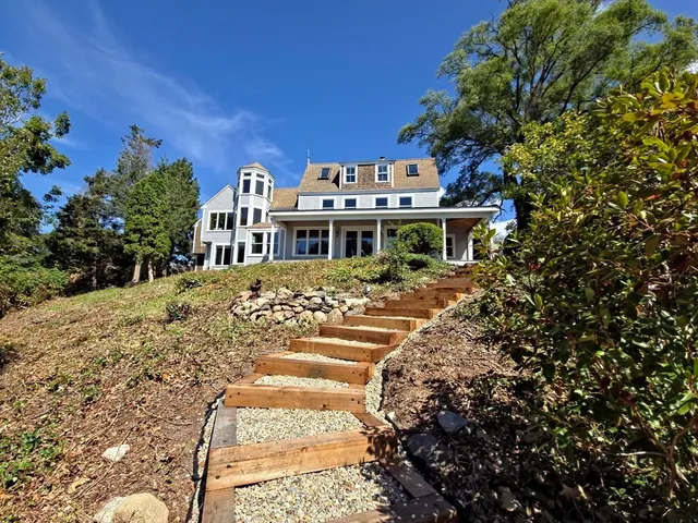 a view of a white house with a yard