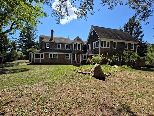a front view of a house with a garden and trees