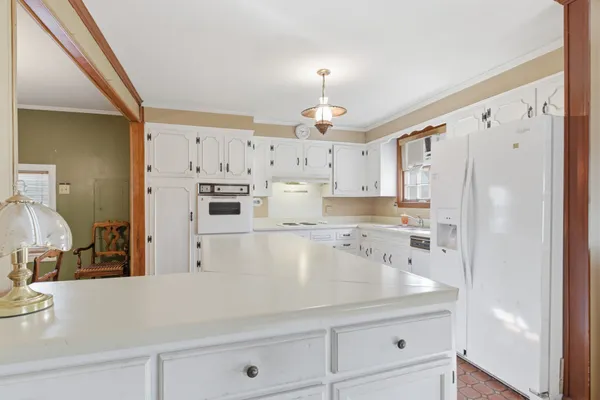 a kitchen with stainless steel appliances a refrigerator sink and white cabinets