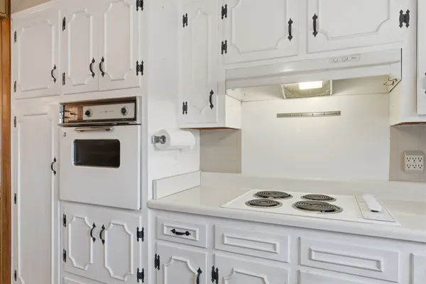 a kitchen with white cabinets and white appliances