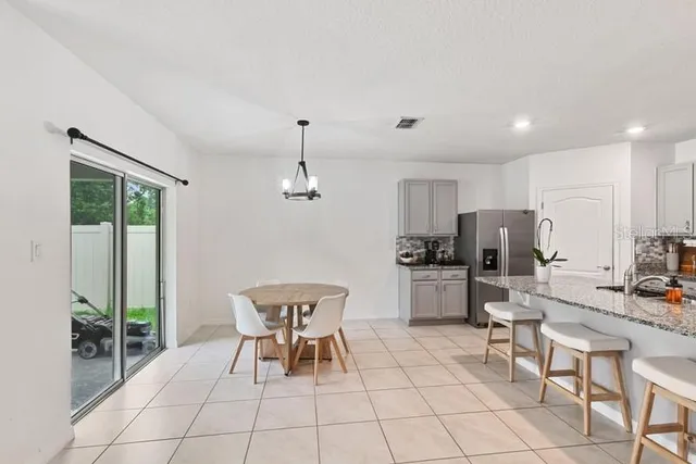a outdoor kitchen with a sink and chairs