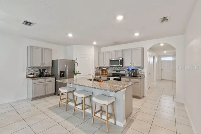 a kitchen with stainless steel appliances a refrigerator sink and white cabinets