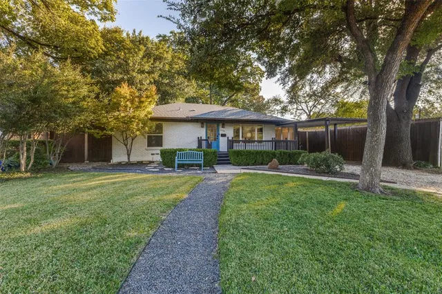 a view of a house with backyard and sitting area