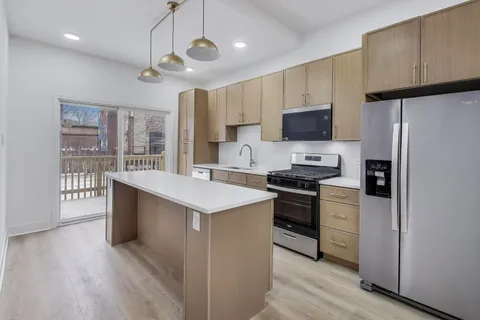 a kitchen with stainless steel appliances a stove a sink a refrigerator and a oven