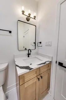 a bathroom with a sink toilet and mirror