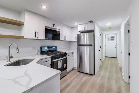 a kitchen with stainless steel appliances granite countertop a refrigerator stove and sink
