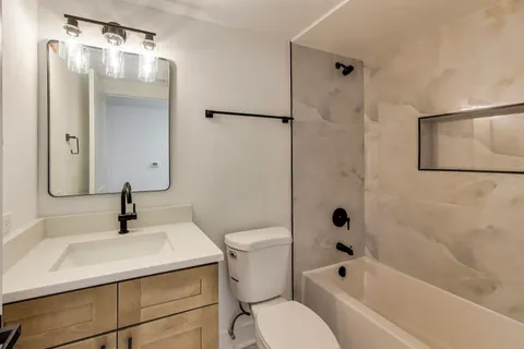 a bathroom with a sink toilet and shower