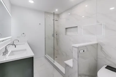 a bathroom with a sink a toilet and shower