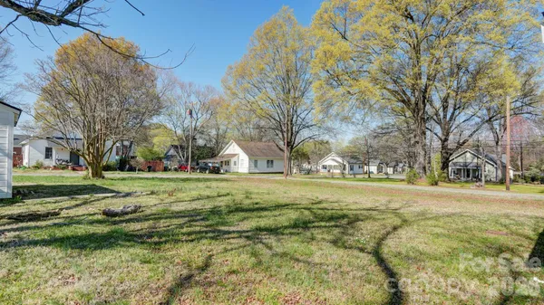 a view of a big yard with large trees