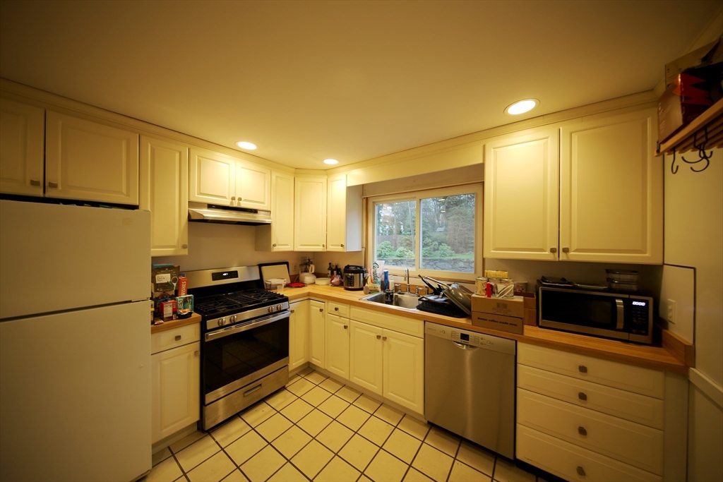23 Heath Street, Unit 1 Brookline, MA 02445 - Photo 5 of 16 a kitchen with stainless steel appliances granite countertop a stove a sink and a refrigerator