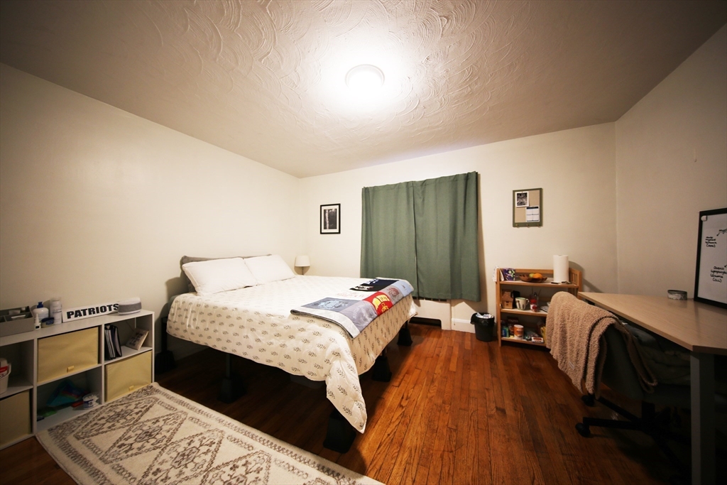 23 Heath Street, Unit 1 Brookline, MA 02445 - Photo 7 of 16 a bed room with a bed and a tv
