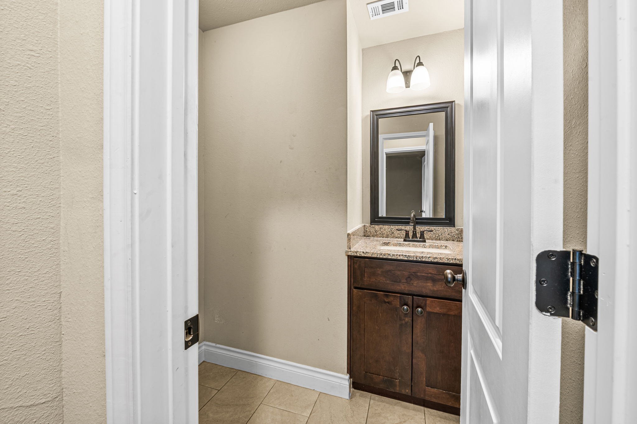 6838 Foster Street Houston, TX 77021 - Photo 18 of 24 Convenient half bathroom with a granite-topped vanity and wood cabinetry