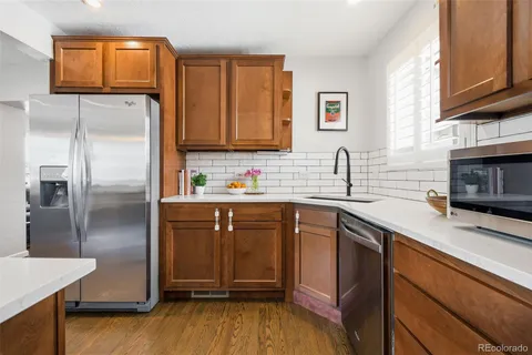 a kitchen with stainless steel appliances granite countertop a refrigerator sink and microwave