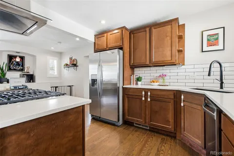 a kitchen with granite countertop a refrigerator stove and sink