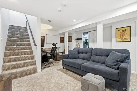 a living room with furniture and stairs