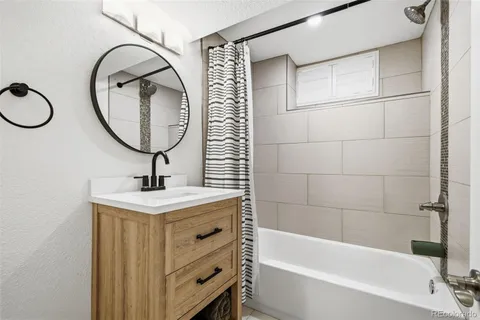 a bathroom with a sink a bathtub and a mirror