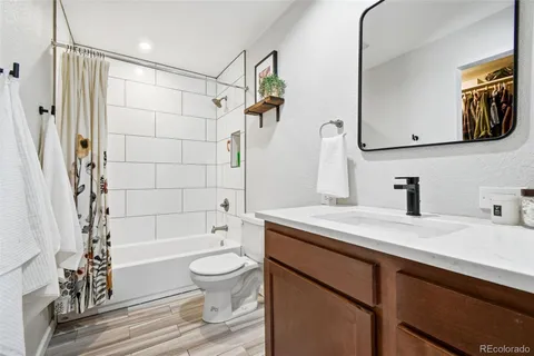a bathroom with a sink a toilet a mirror a bathtub and shower