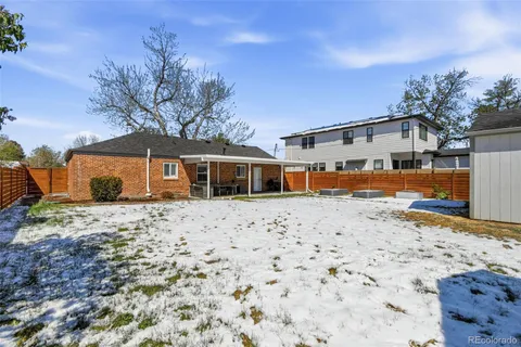 a front view of a house with a yard covered with snow in the background