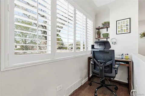 a view of a workspace with furniture and a window