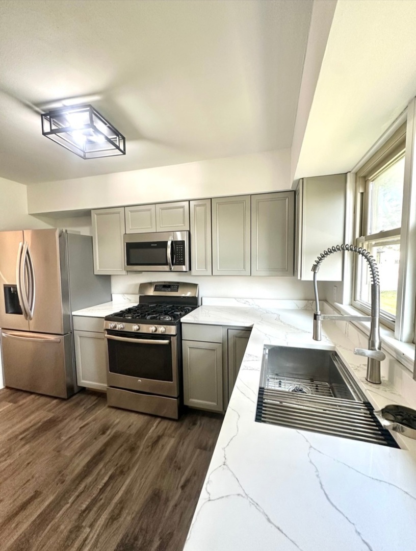 906 West Walnut Street Kankakee, IL 60901 - Photo 6 of 14 a large kitchen with stainless steel appliances granite countertop a stove and a sink
