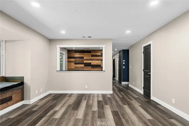 a view of an empty room with wooden floor
