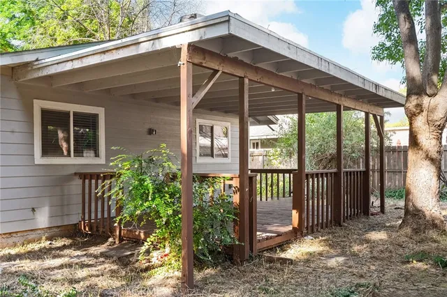 a view of a house with a small yard and wooden fence