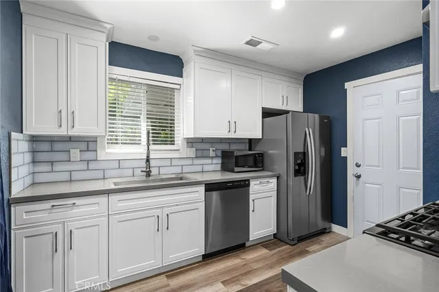 a kitchen with stainless steel appliances granite countertop a refrigerator sink and cabinets