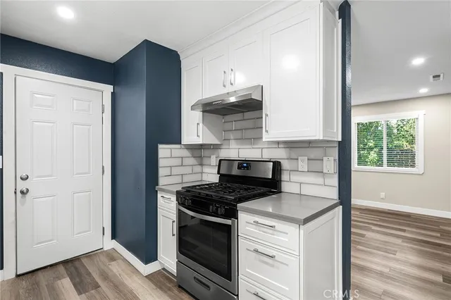 a kitchen with cabinets appliances and a wooden floor