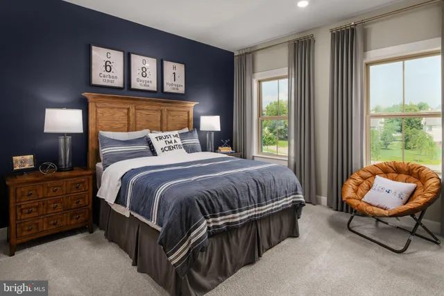 a bedroom with a bed chair and window