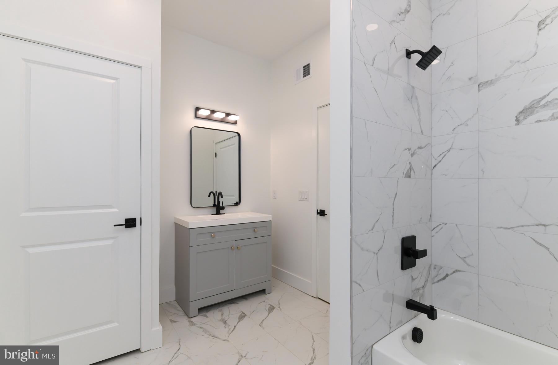 100 Aura Road, Unit 110 Clayton, NJ 08312 - Photo 31 of 34 a bathroom with a bathtub sink vanity and mirror