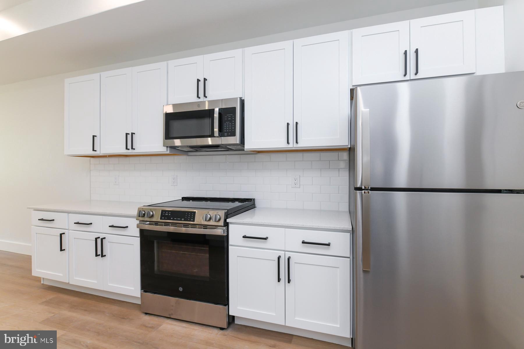 100 Aura Road, Unit 110 Clayton, NJ 08312 - Photo 32 of 34 a kitchen with stainless steel appliances white cabinets and a refrigerator