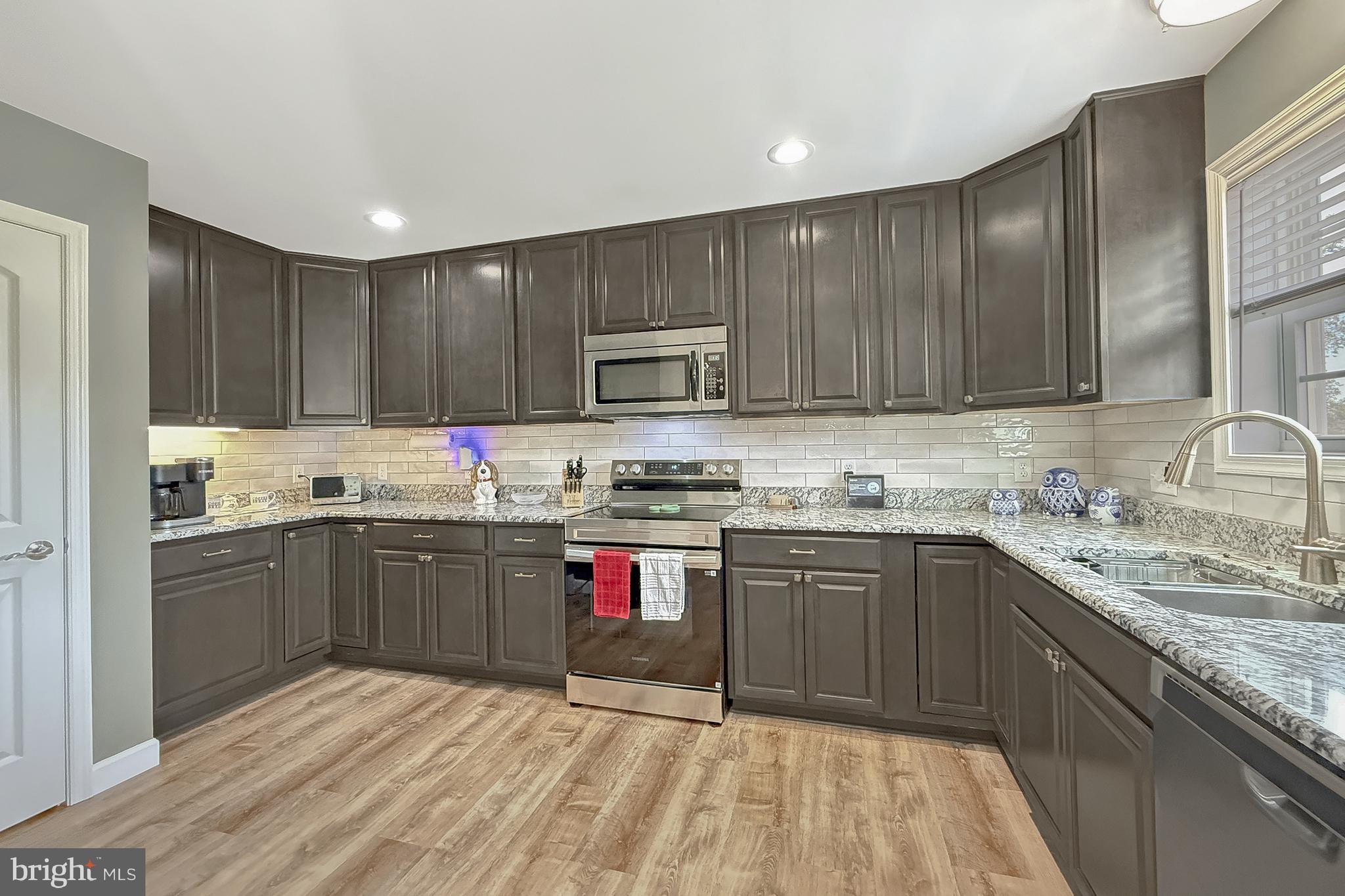 87 Trapper Lane Magnolia, DE 19962 - Photo 17 of 39 a kitchen with granite countertop stainless steel appliances and wooden cabinets