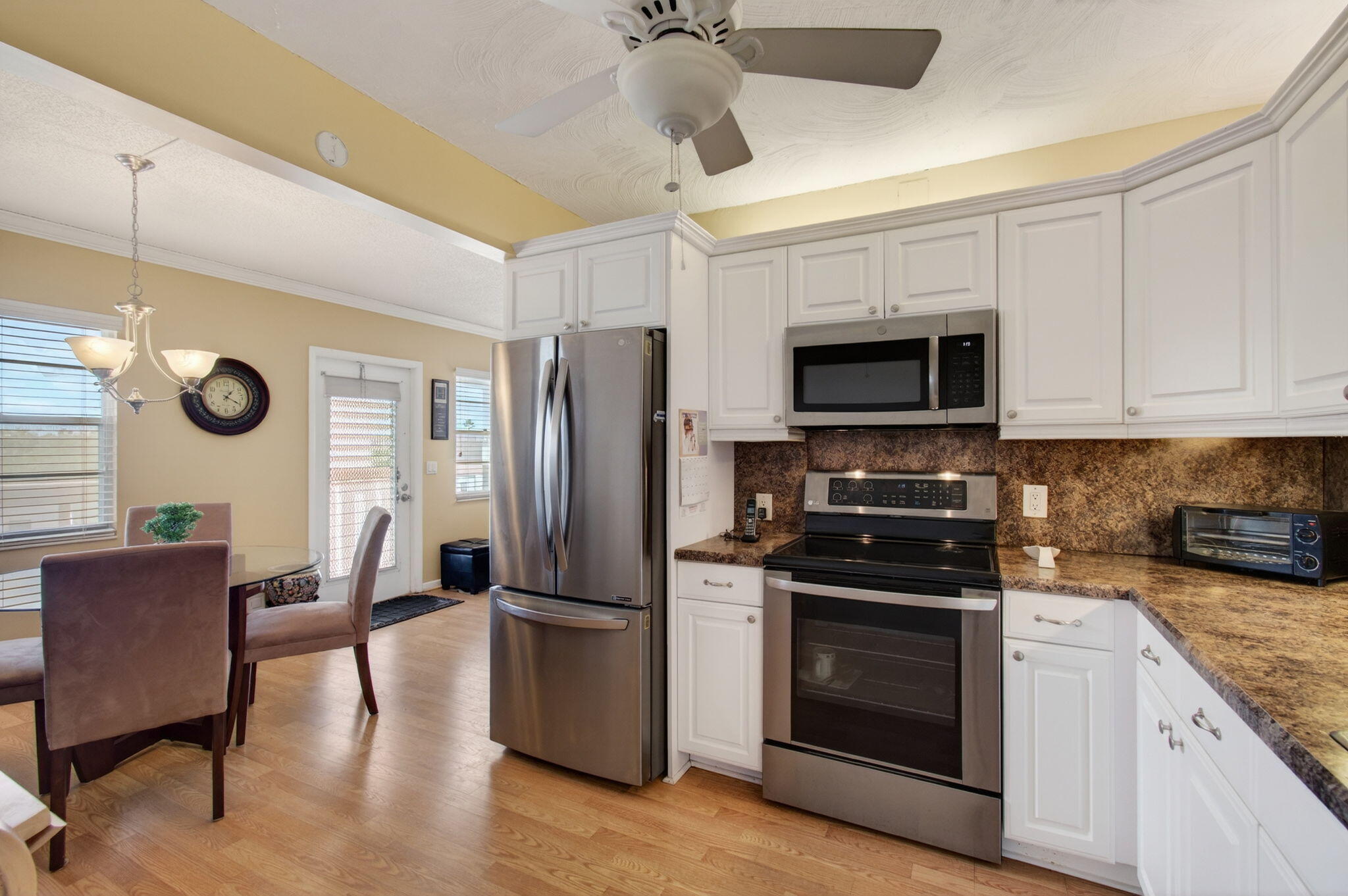 4082 Wolverton East Boca Raton, FL 33434 - Photo 16 of 93 a kitchen with granite countertop a refrigerator a stove a sink a dining table and chairs with wooden floor