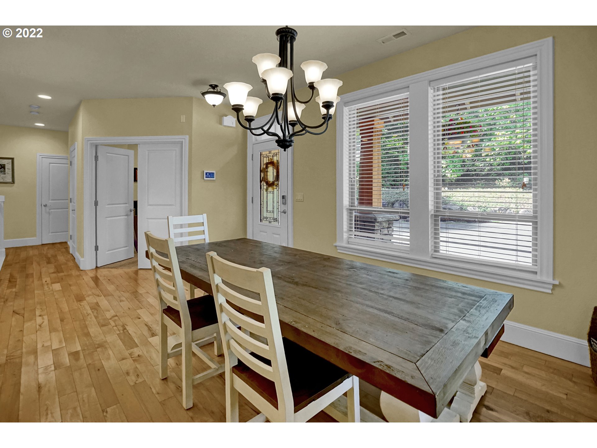 11 Big Tree Road Gleneden Beach, OR 97388 - Photo 3 of 32 a dining room with wooden floor a chandelier a wooden table and chairs