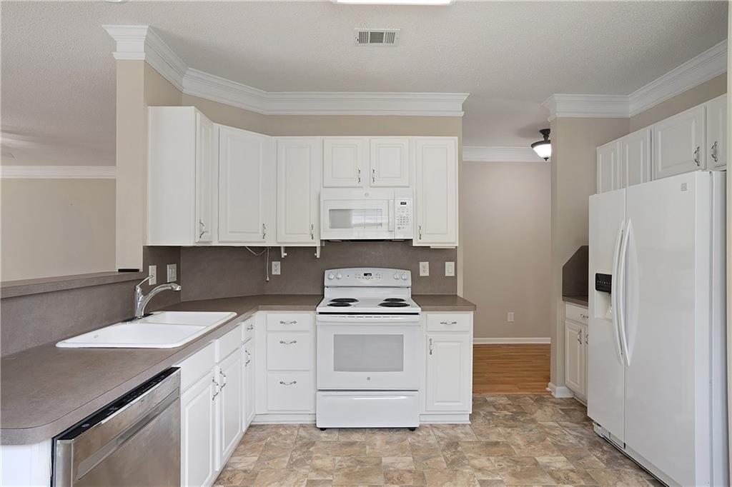17 Williams Pride Way Newnan, GA 30265 - Photo 15 of 28 a kitchen with a stove sink and refrigerator