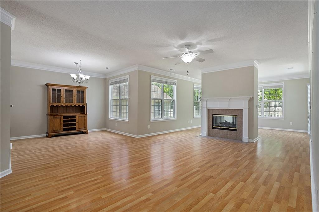 17 Williams Pride Way Newnan, GA 30265 - Photo 5 of 28 an empty room with wooden floor fireplace and windows