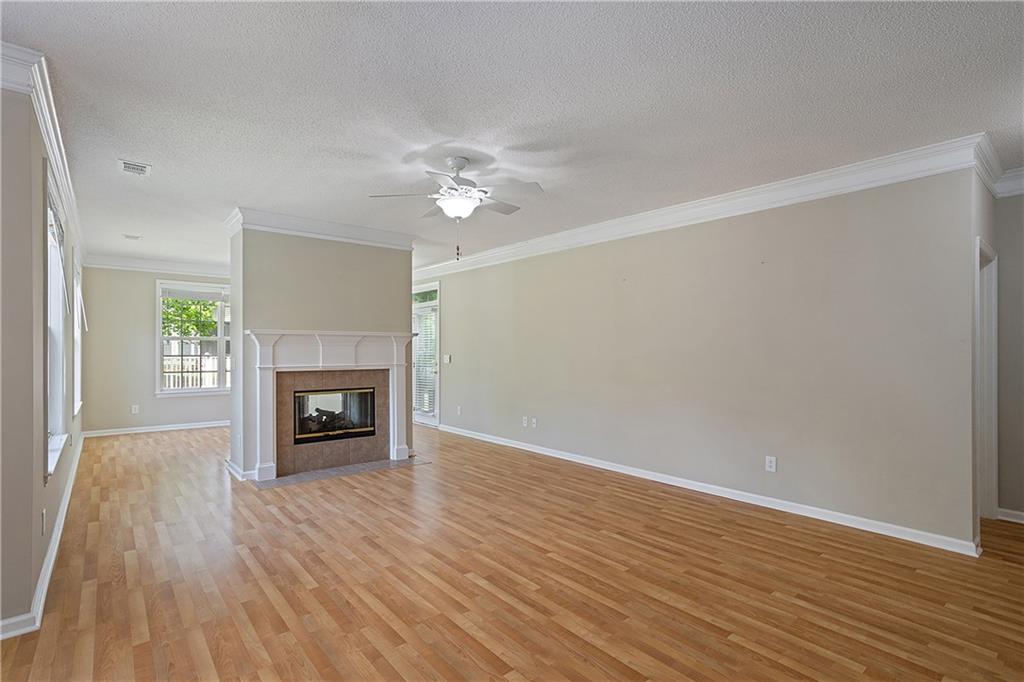 17 Williams Pride Way Newnan, GA 30265 - Photo 9 of 28 an empty room with wooden floor fireplace and windows