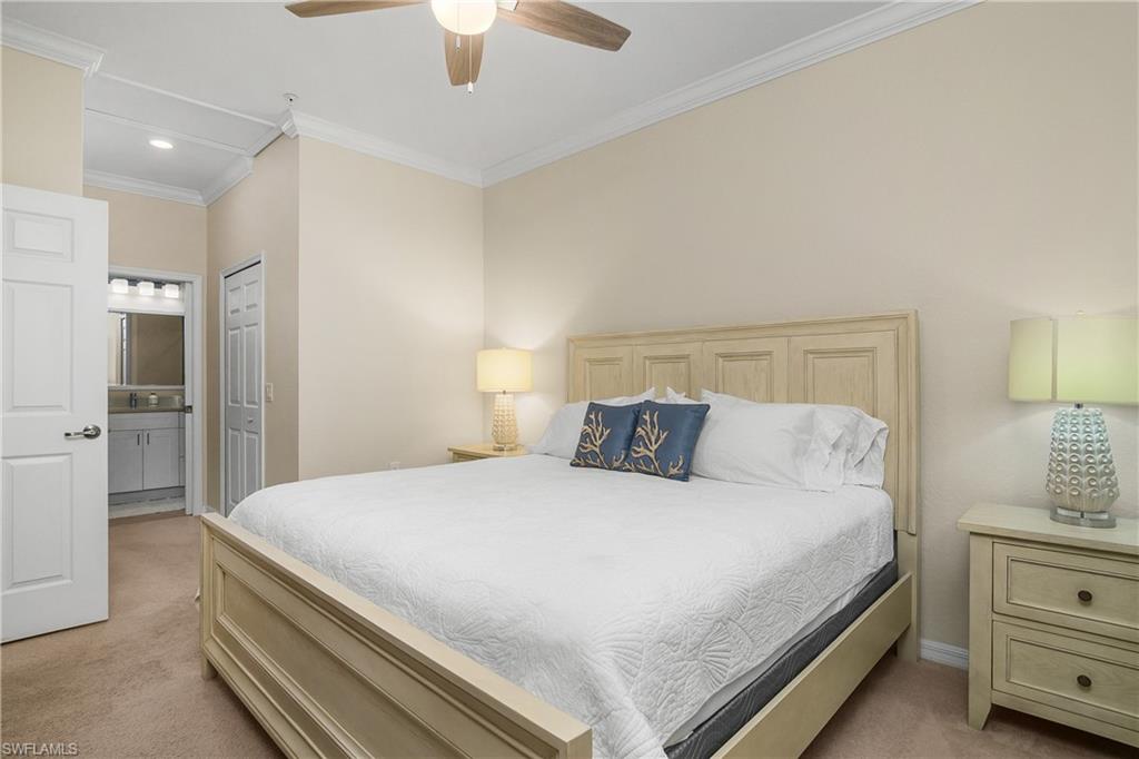 9834 Giaveno Circle, Unit 1746 Naples, FL 34113 - Photo 17 of 41 a bedroom with a bed and a lamp on dresser