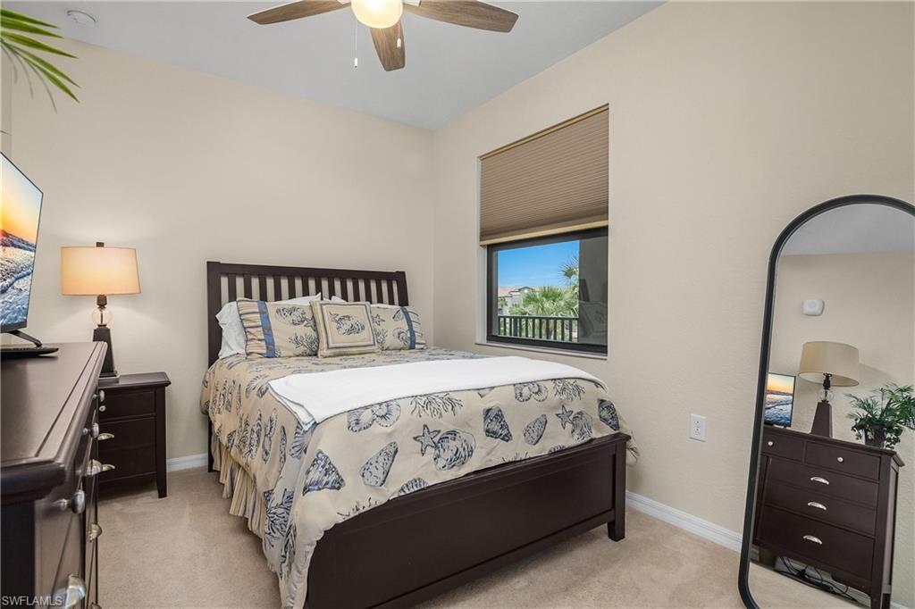 9834 Giaveno Circle, Unit 1746 Naples, FL 34113 - Photo 19 of 41 a bedroom with a bed and a lamp on dresser