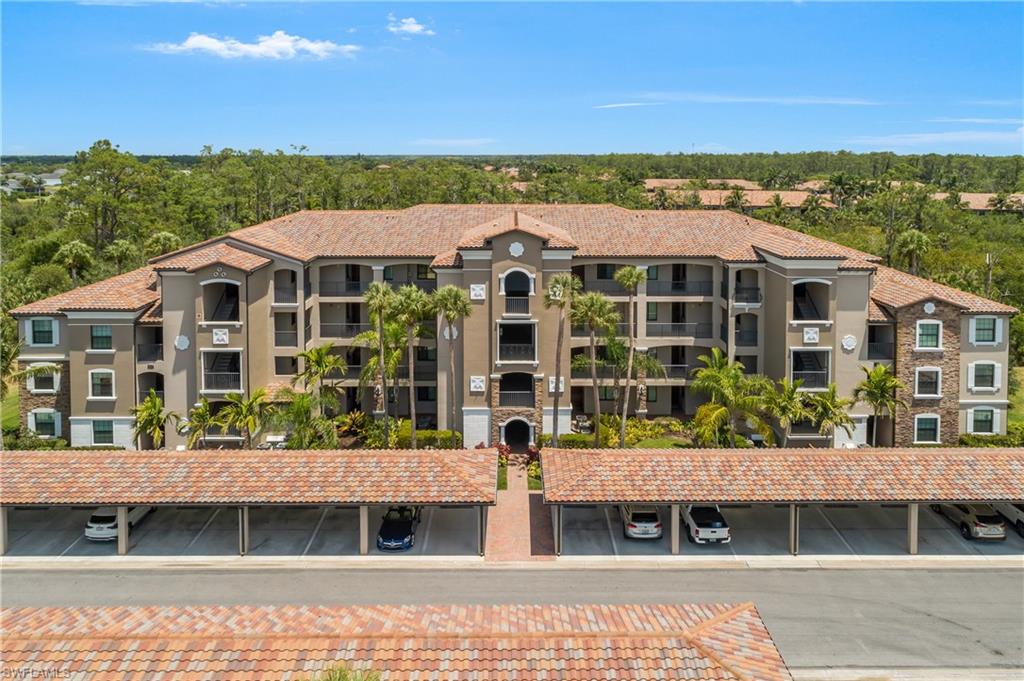 9834 Giaveno Circle, Unit 1746 Naples, FL 34113 - Photo 21 of 41 a front view of a building with a garden